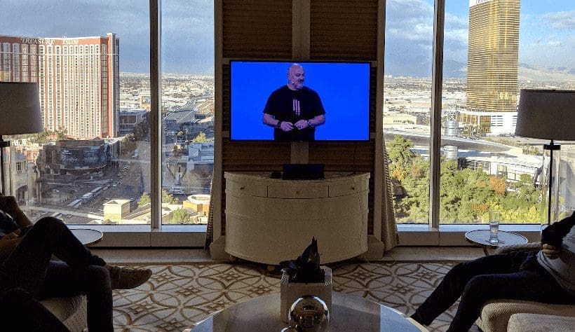Speaker on TV with Versent team watching at AWS Re:Invent Sold Out event in Las Vegas NV